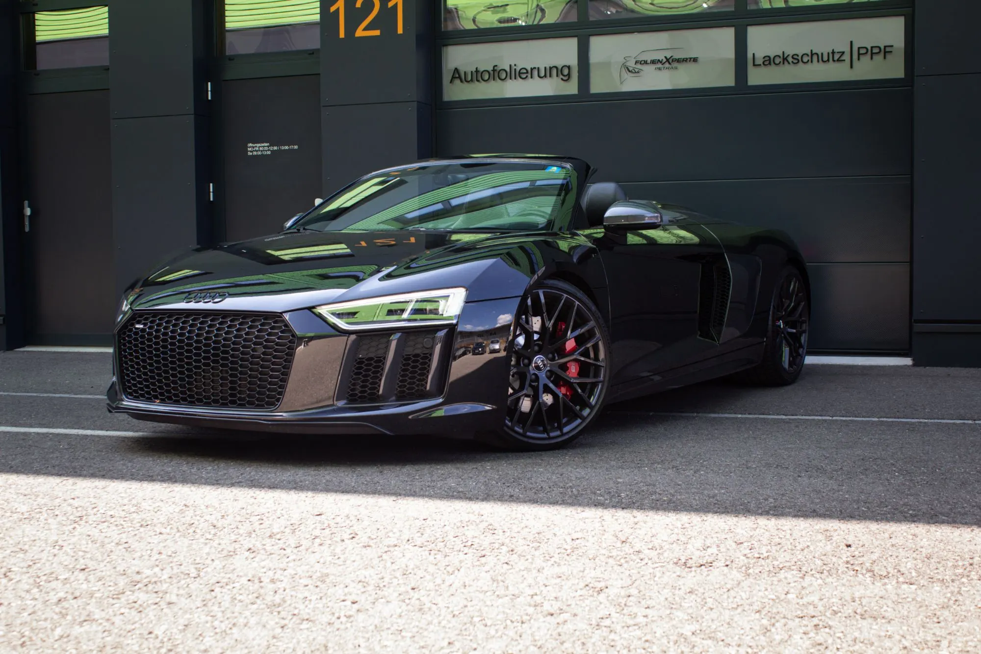 Audi R8 Spyder in Schwarz mit Lackschutzfolie (PPF) vor der Werkstatt von FolienXperte Petras in Balsthal